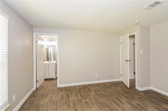 empty room featuring dark hardwood / wood-style floors and a textured ceiling