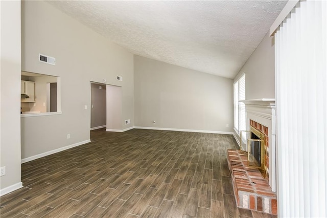 unfurnished living room with a brick fireplace, dark wood-type flooring, a textured ceiling, and vaulted ceiling