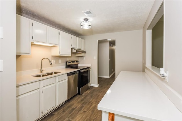 kitchen featuring dark hardwood / wood-style floors, sink, white cabinets, stainless steel appliances, and a textured ceiling