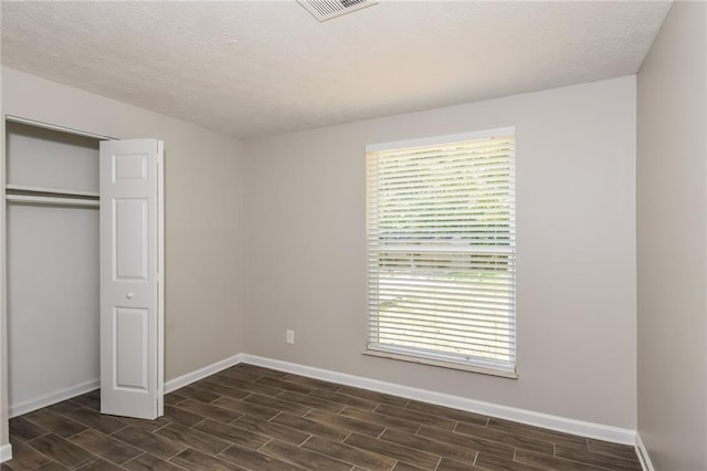 unfurnished bedroom with a textured ceiling and a closet