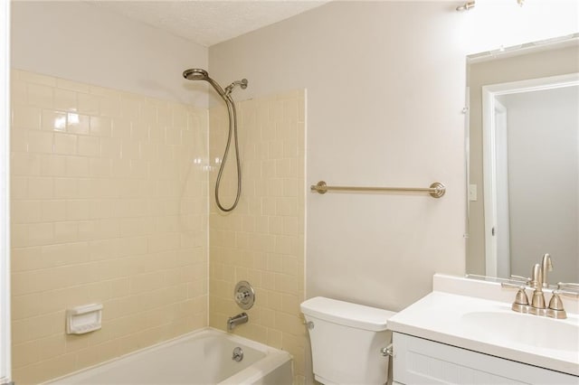 full bathroom featuring tiled shower / bath, vanity, toilet, and a textured ceiling