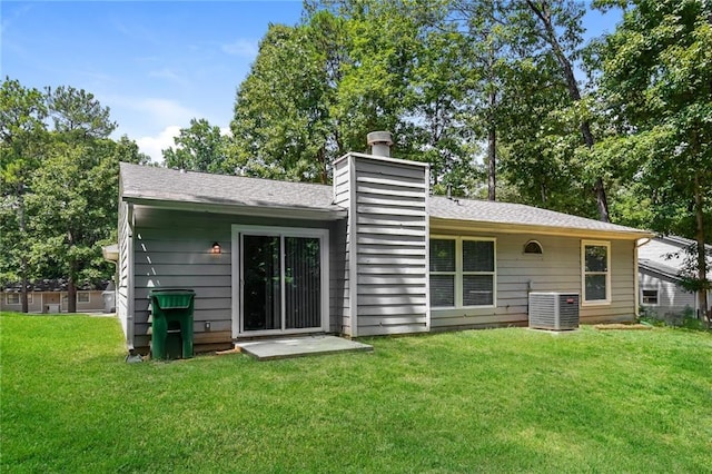 back of property with cooling unit and a yard