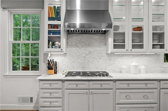 5545 Cross Gate Ct, Atlanta, GA 30327 - kitchen featuring wall chimney exhaust hood, tasteful backsplash, stainless steel gas stovetop, and glass insert cabinets