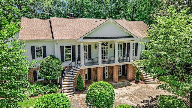 5545 Cross Gate Ct, Atlanta, GA 30327 - greek revival inspired property with stairs, covered porch, stucco siding, and roof with shingles