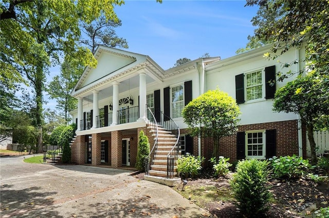 5545 Cross Gate Ct, Atlanta, GA 30327 - neoclassical / greek revival house featuring stairway, a porch, brick siding, driveway, and stucco siding