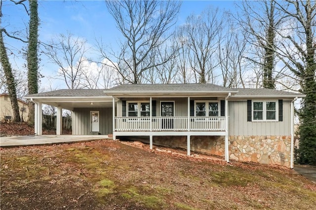 single story home featuring a carport, stone siding, a porch, and board and batten siding