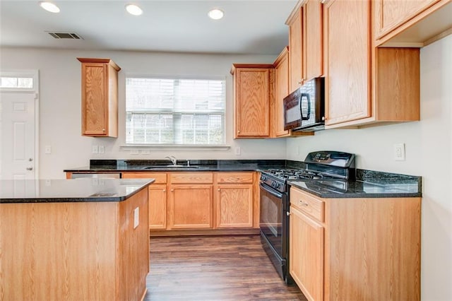 kitchen featuring dark hardwood / wood-style floors, light brown cabinetry, sink, dark stone counters, and black appliances