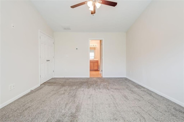 carpeted spare room featuring ceiling fan