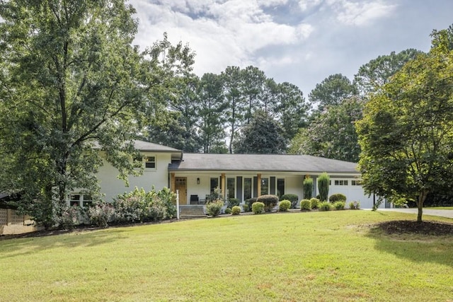 view of front of home with a porch, a garage, and a front yard