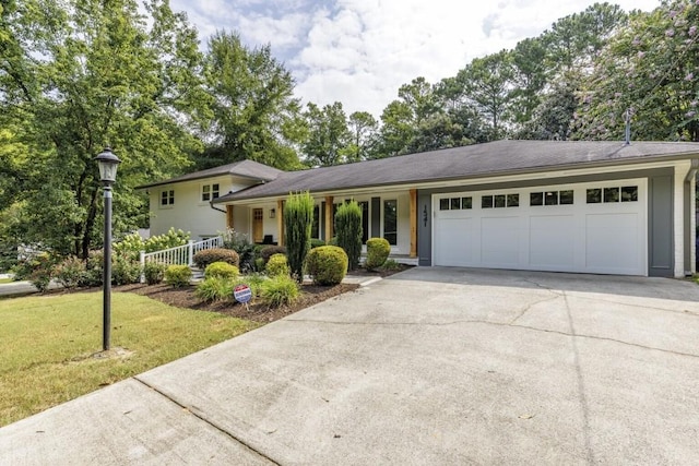 view of front of property featuring a porch, a garage, and a front lawn