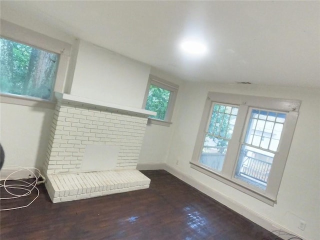 living room with dark hardwood / wood-style flooring and a brick fireplace