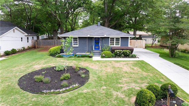view of front of property with fence, concrete driveway, and a front yard