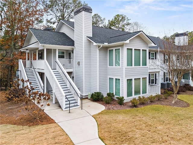 exterior space featuring a porch, central AC unit, and a front lawn