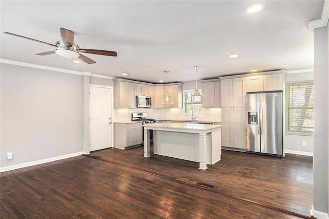 kitchen with tasteful backsplash, a kitchen island, stainless steel appliances, crown molding, and pendant lighting