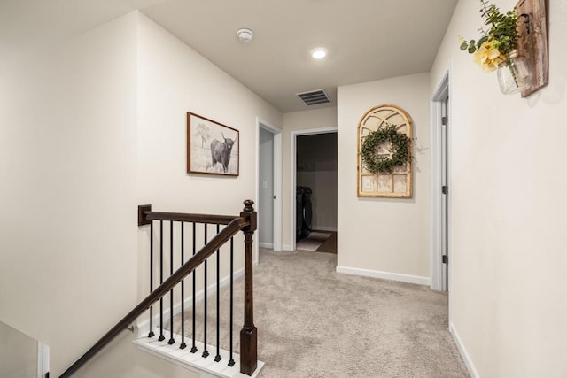 hall featuring light colored carpet