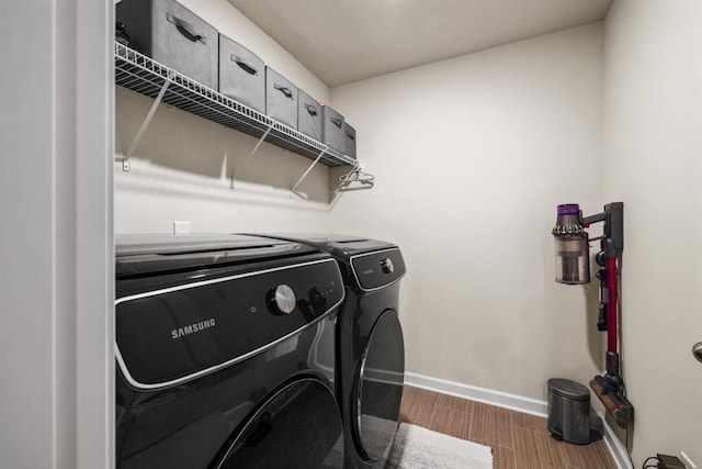 laundry room featuring washer and dryer and dark wood-type flooring