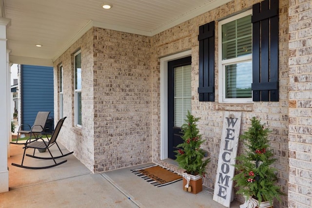 view of exterior entry featuring covered porch