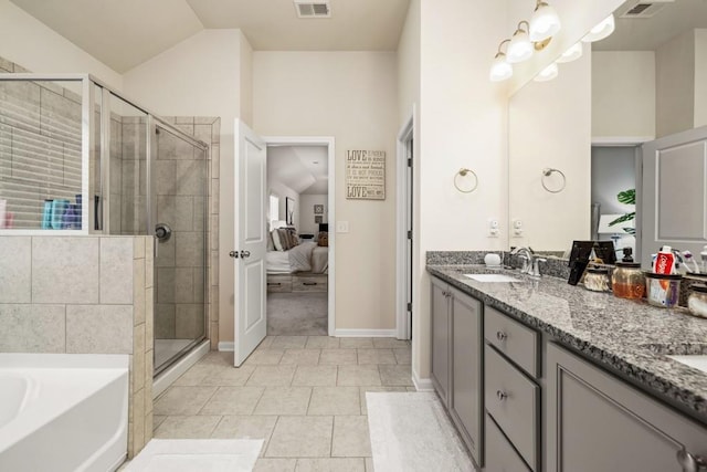 bathroom with tile patterned floors, vanity, vaulted ceiling, and separate shower and tub