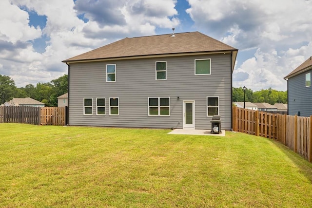 rear view of property featuring a lawn and a patio area