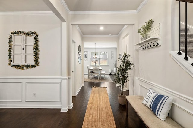 hall with dark hardwood / wood-style flooring, crown molding, and a notable chandelier