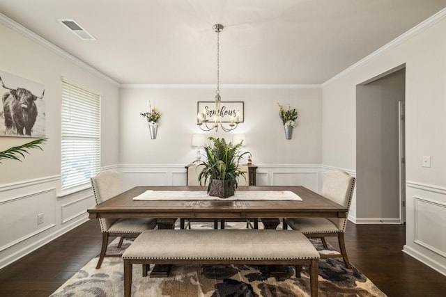 dining room with a chandelier, dark wood-type flooring, and ornamental molding