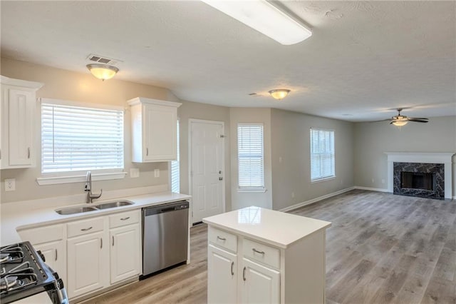 kitchen with a fireplace, visible vents, black gas range oven, a sink, and dishwasher