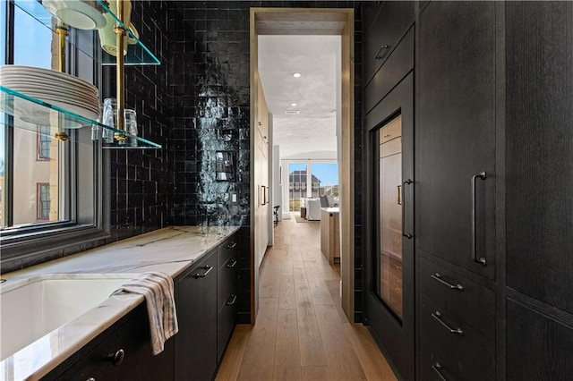 bathroom with hardwood / wood-style flooring, tasteful backsplash, and vanity