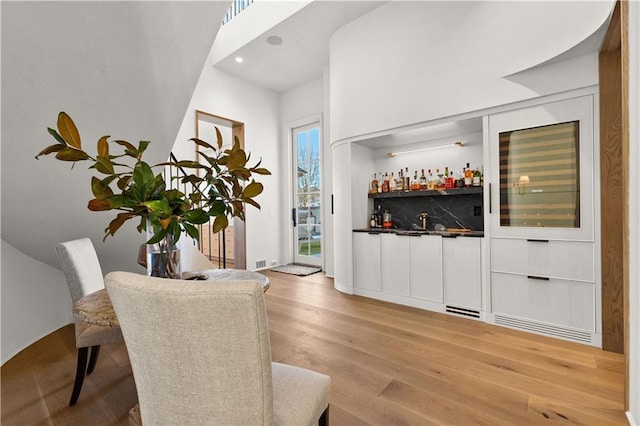 bar with light hardwood / wood-style floors