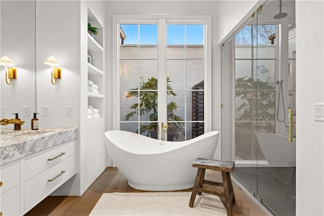 bathroom featuring vanity, hardwood / wood-style flooring, and separate shower and tub