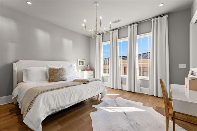 bedroom featuring a notable chandelier and light hardwood / wood-style floors