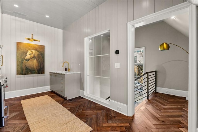 bathroom with sink, parquet flooring, and vaulted ceiling