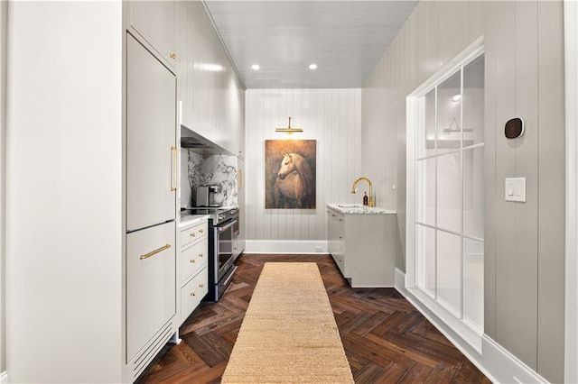 kitchen featuring white cabinetry, sink, electric range, and dark parquet floors