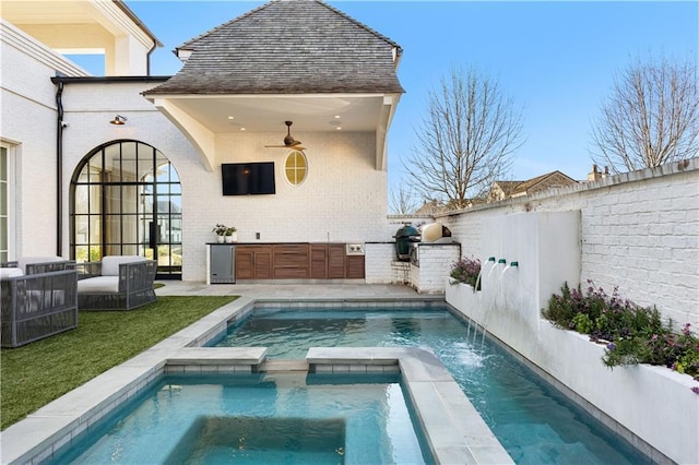 back of house featuring a swimming pool with hot tub, pool water feature, and ceiling fan