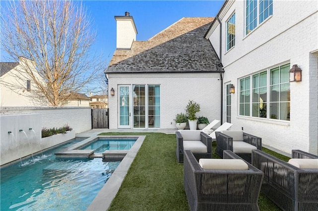 rear view of house featuring an outdoor living space, a swimming pool with hot tub, a yard, and pool water feature