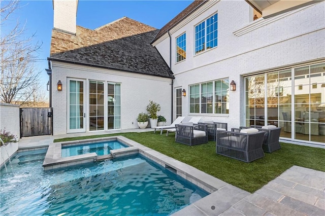 back of property featuring a swimming pool with hot tub, an outdoor hangout area, a patio area, and a lawn