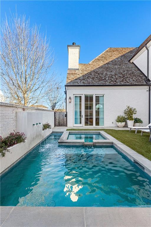 view of pool featuring an in ground hot tub and pool water feature