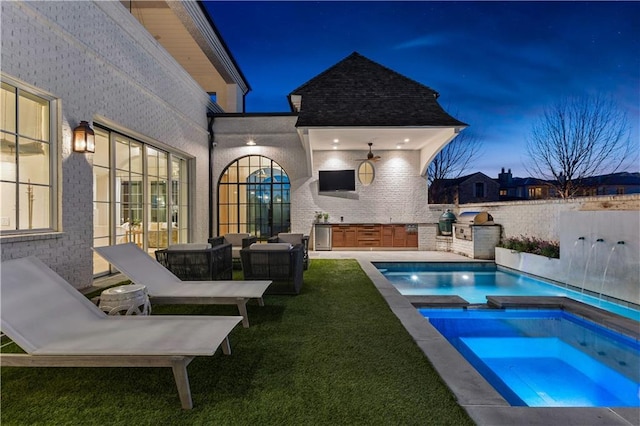 view of pool featuring a patio, a lawn, area for grilling, an in ground hot tub, and pool water feature