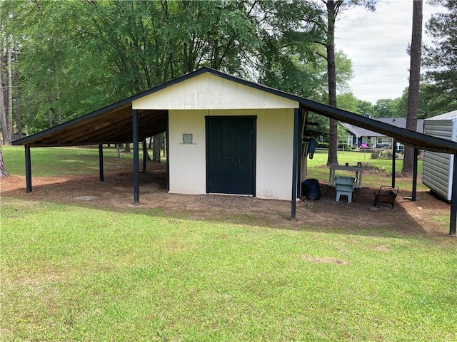 view of outdoor structure featuring a carport and an outbuilding