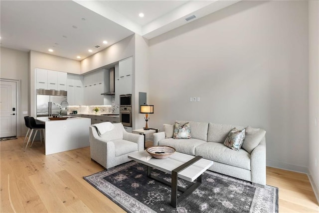 living room with light hardwood / wood-style flooring and sink