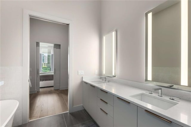 bathroom featuring tile patterned flooring, vanity, and a tub