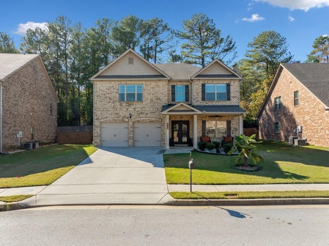 view of front of property with a front yard, french doors, a garage, and central air condition unit