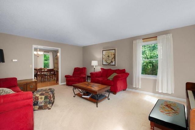 carpeted living room featuring a notable chandelier and plenty of natural light