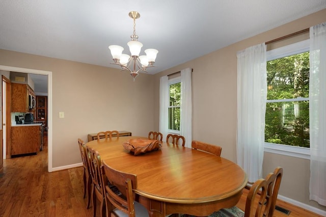 dining room with a notable chandelier and wood-type flooring