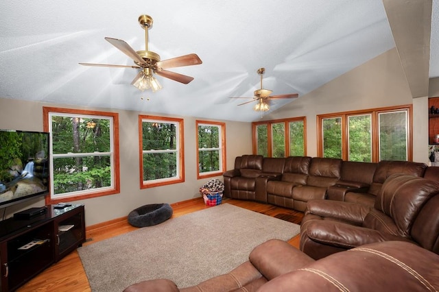 living room featuring light hardwood / wood-style floors, vaulted ceiling, and ceiling fan