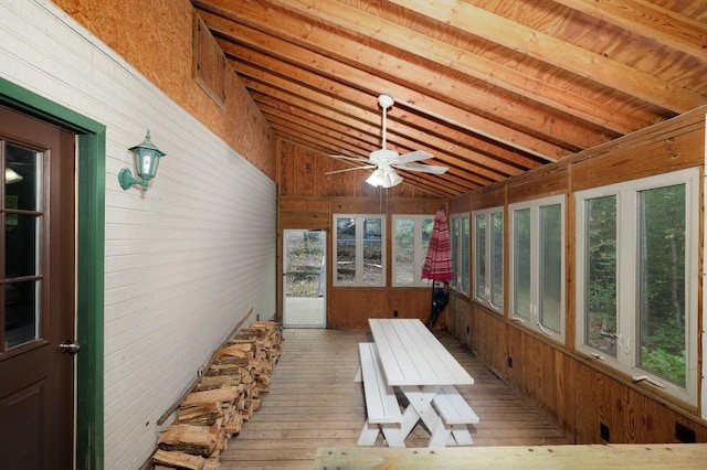 unfurnished sunroom with ceiling fan and lofted ceiling with beams