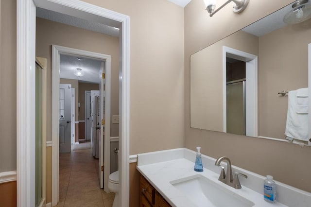 bathroom featuring vanity, tile patterned flooring, and toilet