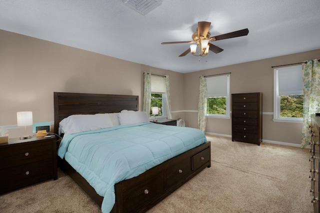 bedroom featuring light carpet, multiple windows, and ceiling fan