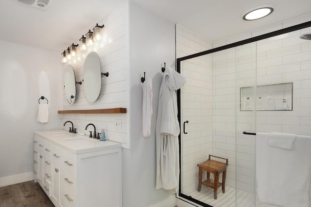 bathroom with wood-type flooring, vanity, decorative backsplash, and an enclosed shower