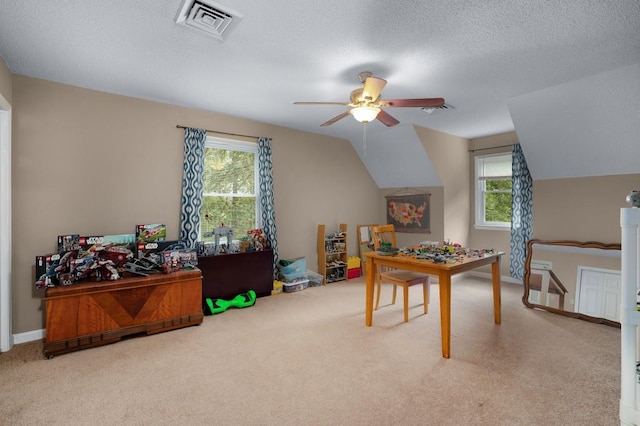 playroom featuring lofted ceiling, ceiling fan, carpet flooring, and a textured ceiling