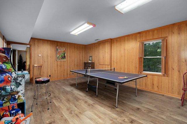 recreation room featuring hardwood / wood-style flooring and wood walls